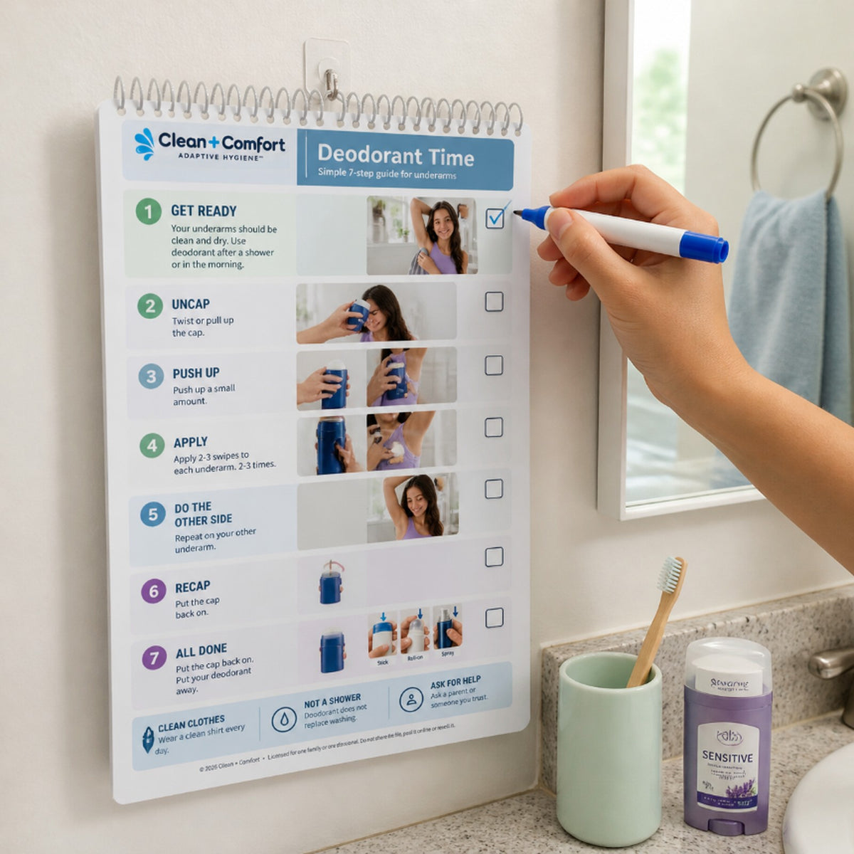 Teen Personal Care Pack laminated spiral-bound book hanging in a bathroom, checklist being marked with a dry-erase marker